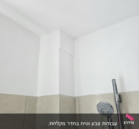 מקלחת עם אריחים לבנים וראש מקלחת מתכת